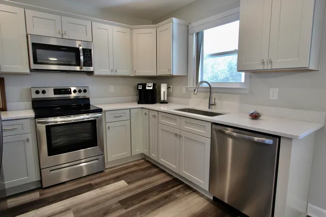 a kitchen with stainless steel appliances a sink a stove and microwave