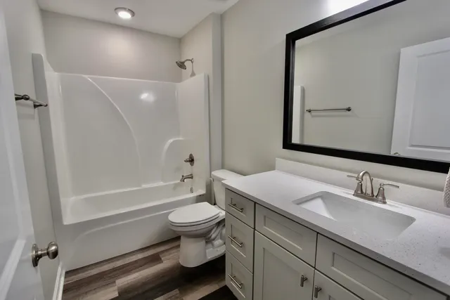 a view of a room with wooden floor and chandelier fan