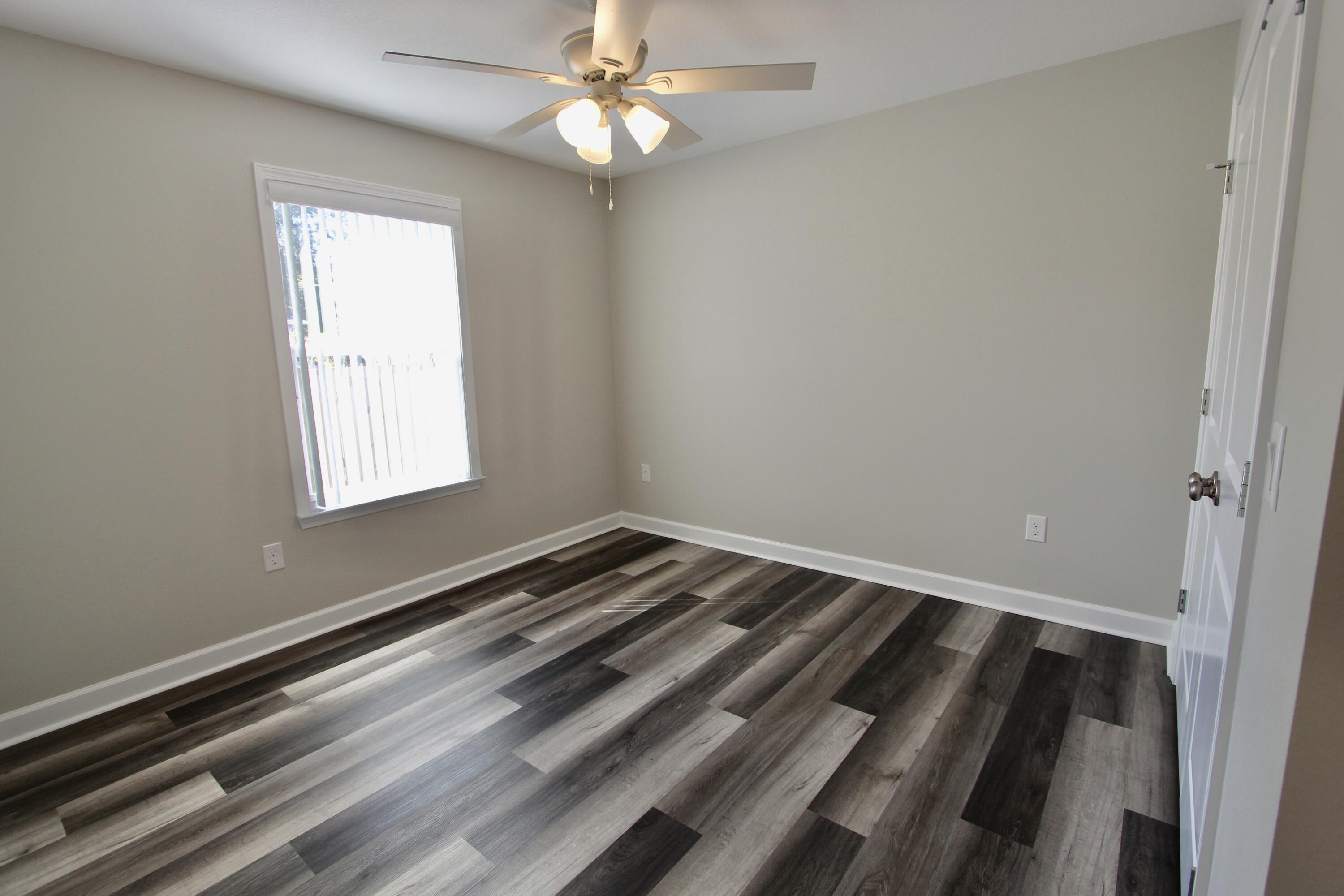 6447 Georgia Avenue Crestview, FL 32539 - Photo 27 of 36 a view of a room with wooden floor and chandelier fan