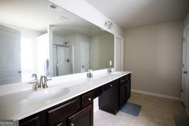 a bathroom with a sink double vanity and a mirror