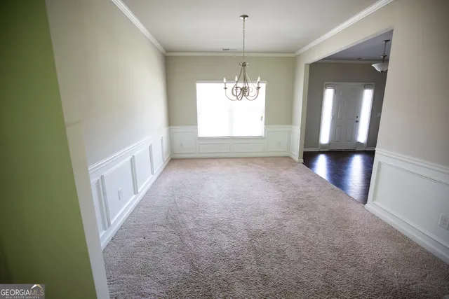 en empty room with windows and chandelier