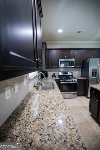 a kitchen with stainless steel appliances kitchen island granite countertop a stove a sink and a microwave
