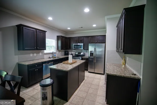 a kitchen with stainless steel appliances granite countertop a refrigerator stove microwave and sink