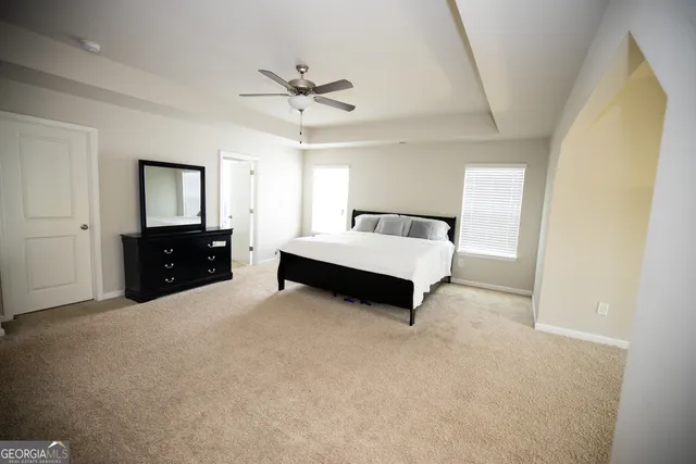 a living room with furniture and a ceiling fan