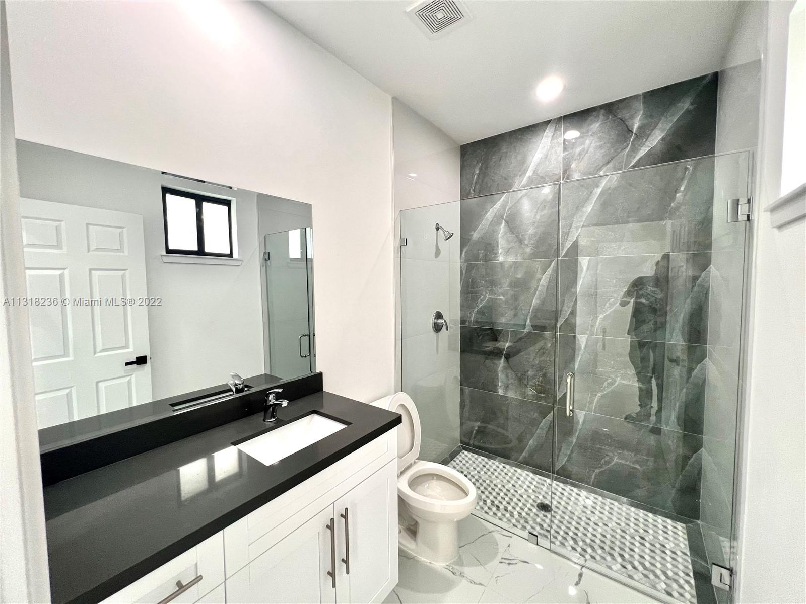 964 Rutherford Lane Haverhill, FL 33415 - Photo 11 of 18 a bathroom with a double vanity sink toilet and shower