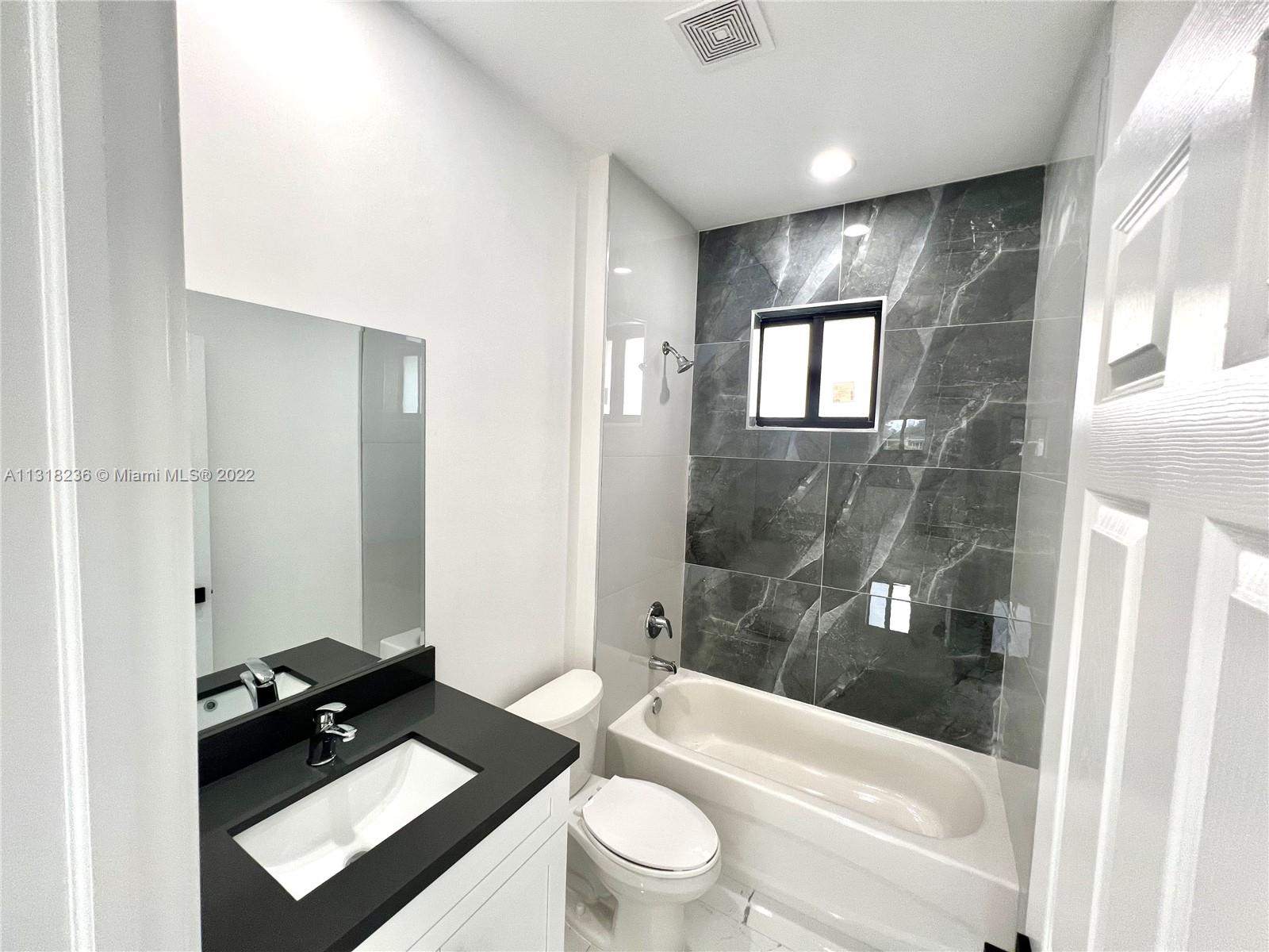964 Rutherford Lane Haverhill, FL 33415 - Photo 15 of 18 a bathroom with a toilet a sink and bathtub