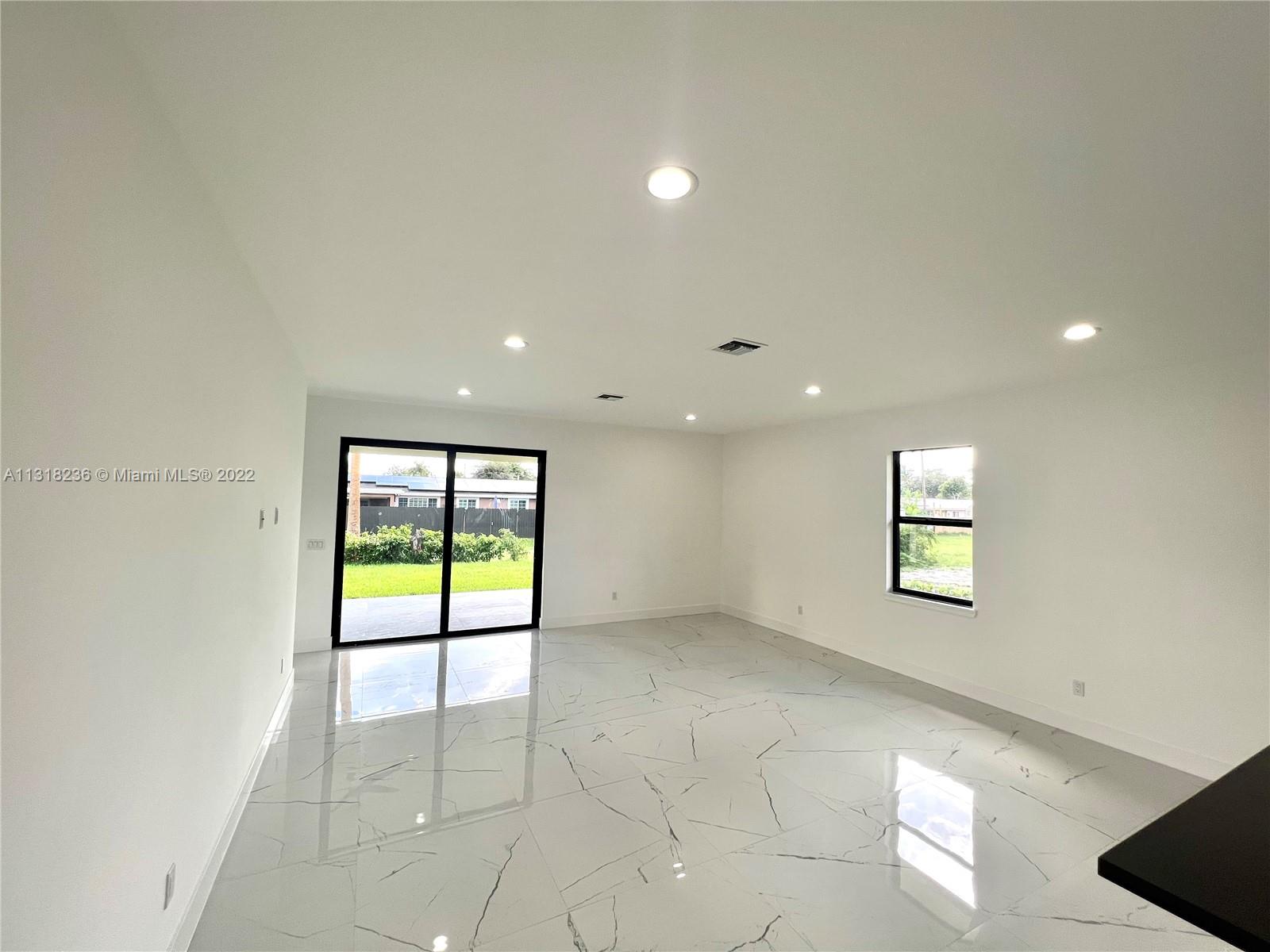 964 Rutherford Lane Haverhill, FL 33415 - Photo 9 of 18 an empty room with windows and entrance