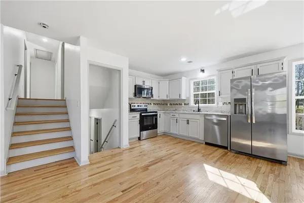 a kitchen with white cabinets and stainless steel appliances