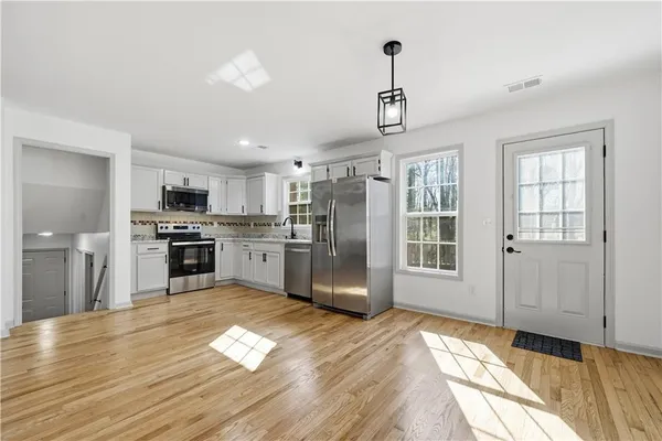 a kitchen with granite countertop stainless steel appliances cabinets a sink and a counter top space