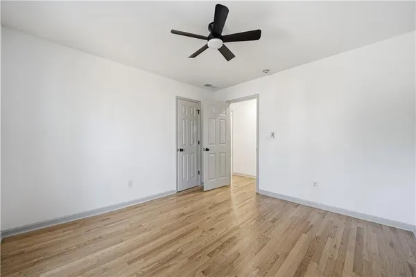 a view of empty room with wooden floor
