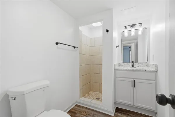 a bathroom with a granite countertop sink toilet and shower