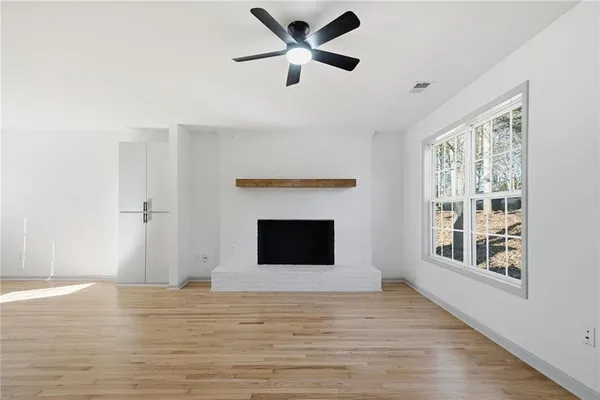 a view of an empty room with a window and a fireplace