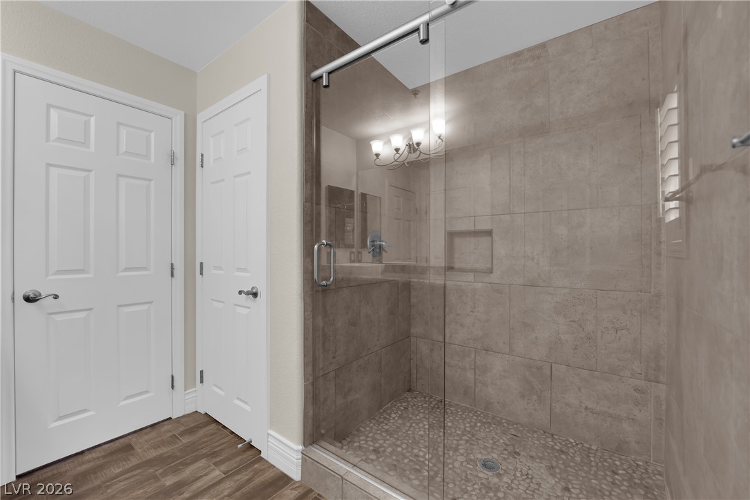 646 Monument Point Street Henderson, NV 89002 - Photo 27 of 44 A spacious, glass-enclosed shower boasts sleek tile and a natural stone pebble floor.