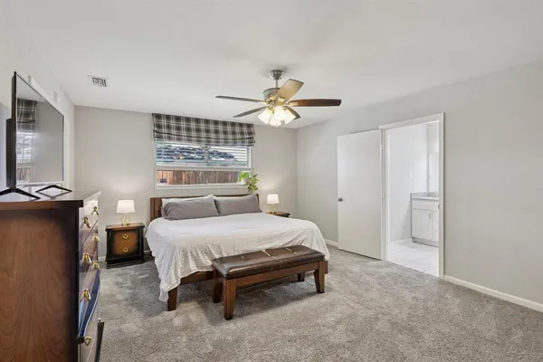 a bedroom with a bed and a ceiling fan
