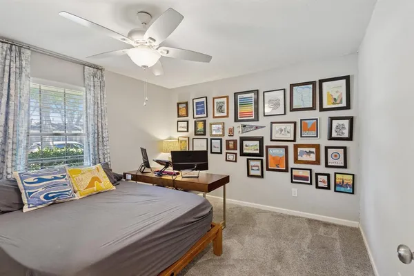a bedroom with a bed a large window and book shelf
