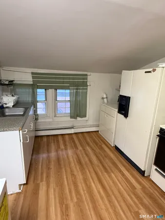 a view of an empty room with a fireplace and wooden floor
