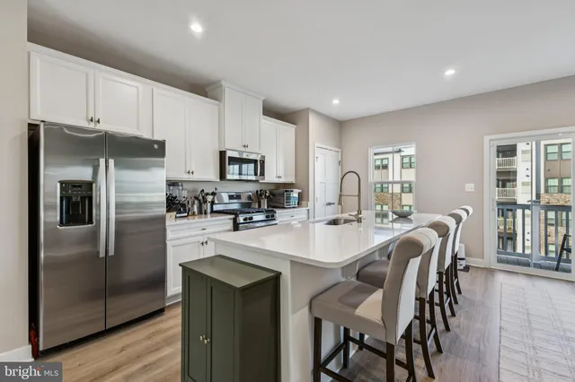 a kitchen with refrigerator and chairs