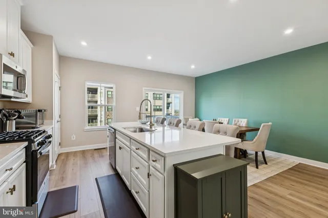 a kitchen with kitchen island a sink stove and cabinets
