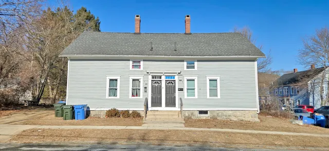 a front view of a house with a road