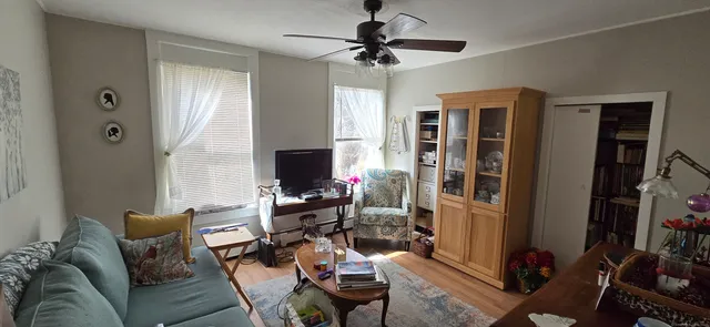 a living room with furniture a flat screen tv and a window