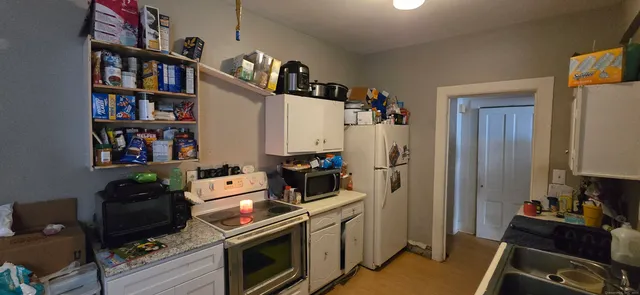 a kitchen with stainless steel appliances a stove and a bookshelf