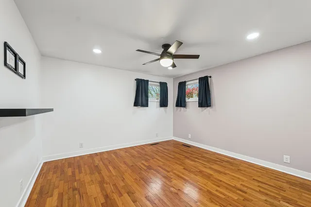 a view of a big room with wooden floor and a ceiling fan