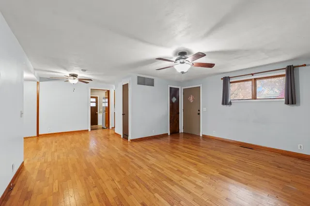 a view of an empty room with wooden floor