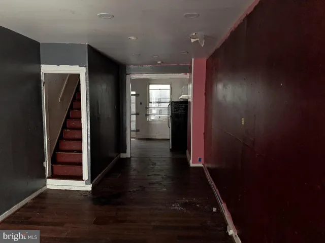 an entryway in a hall with wooden floor and a cabinet