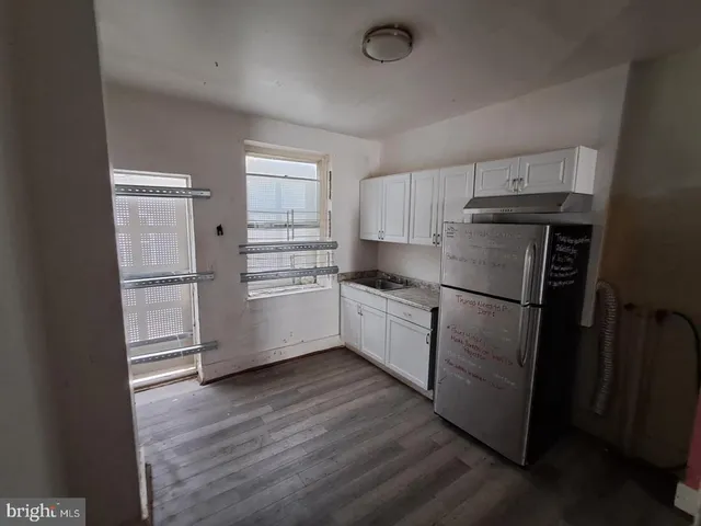 a kitchen with granite countertop a refrigerator and a stove top oven