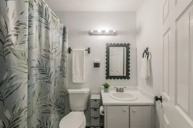 a bathroom with a sink and mirror with toilet