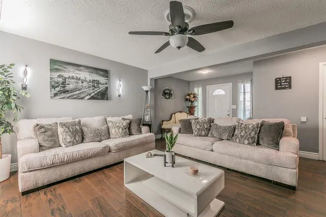 a living room with furniture and a ceiling fan