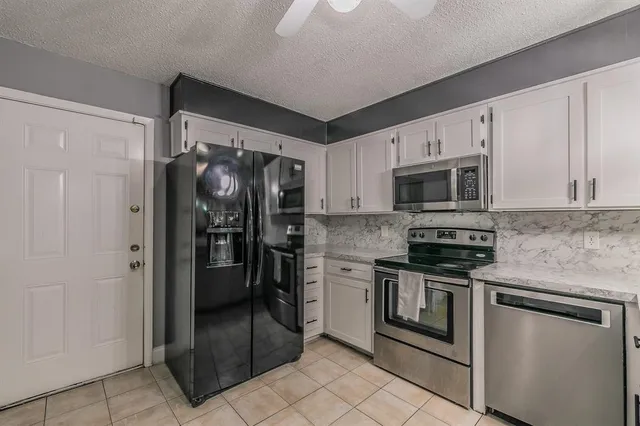 a kitchen with stainless steel appliances granite countertop a refrigerator and a stove top oven