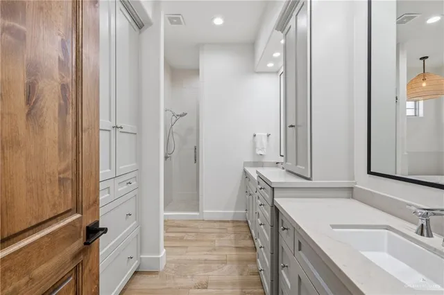 a bathroom with a sink and a mirror with bathtub