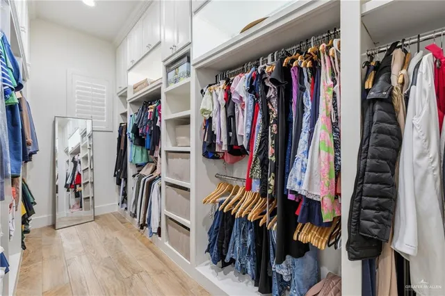 a view of walk in closet with clothes
