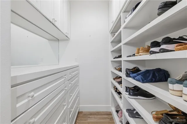 a view of walk in closet with clothes and shoes