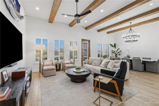 a living room with furniture a flat screen tv and a large window