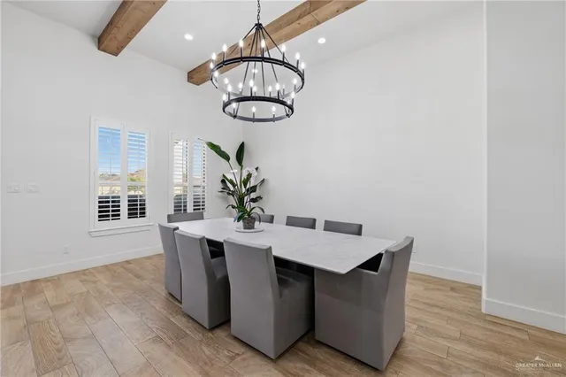 a room with a chandelier and wooden floor