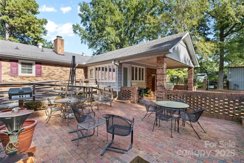 a view of a patio with a dining table and chairs with wooden fence