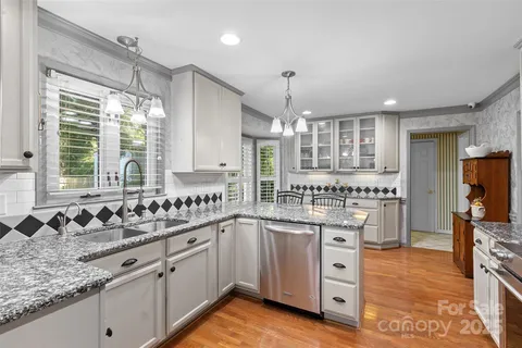a kitchen with stainless steel appliances granite countertop a sink and cabinets