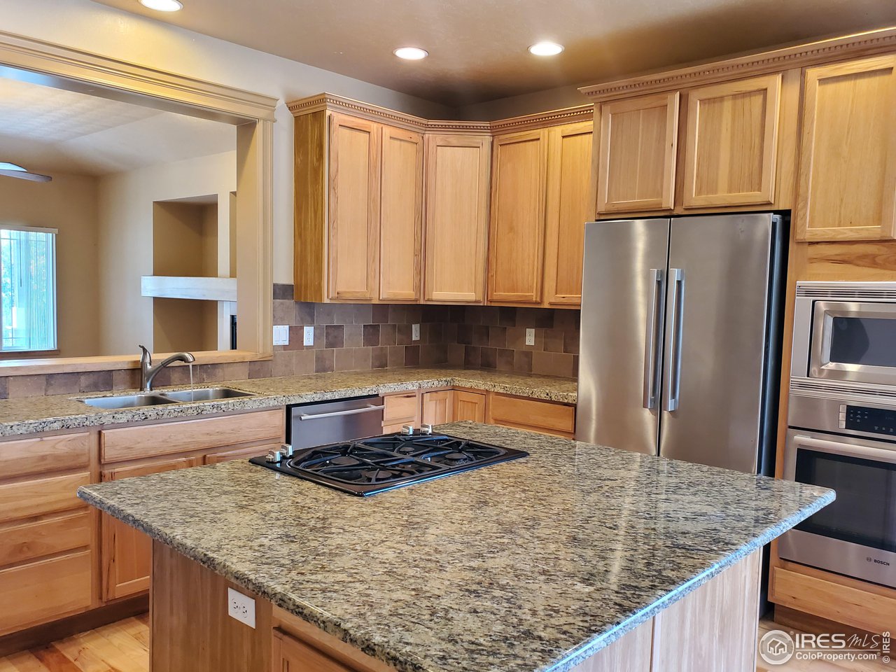 6541 West 18th Street Road Greeley, CO 80634 - Photo 14 of 40 a kitchen with kitchen island granite countertop a sink refrigerator and cabinets