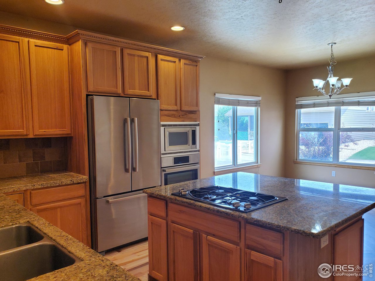 6541 West 18th Street Road Greeley, CO 80634 - Photo 15 of 40 a kitchen with a refrigerator and a stove top oven