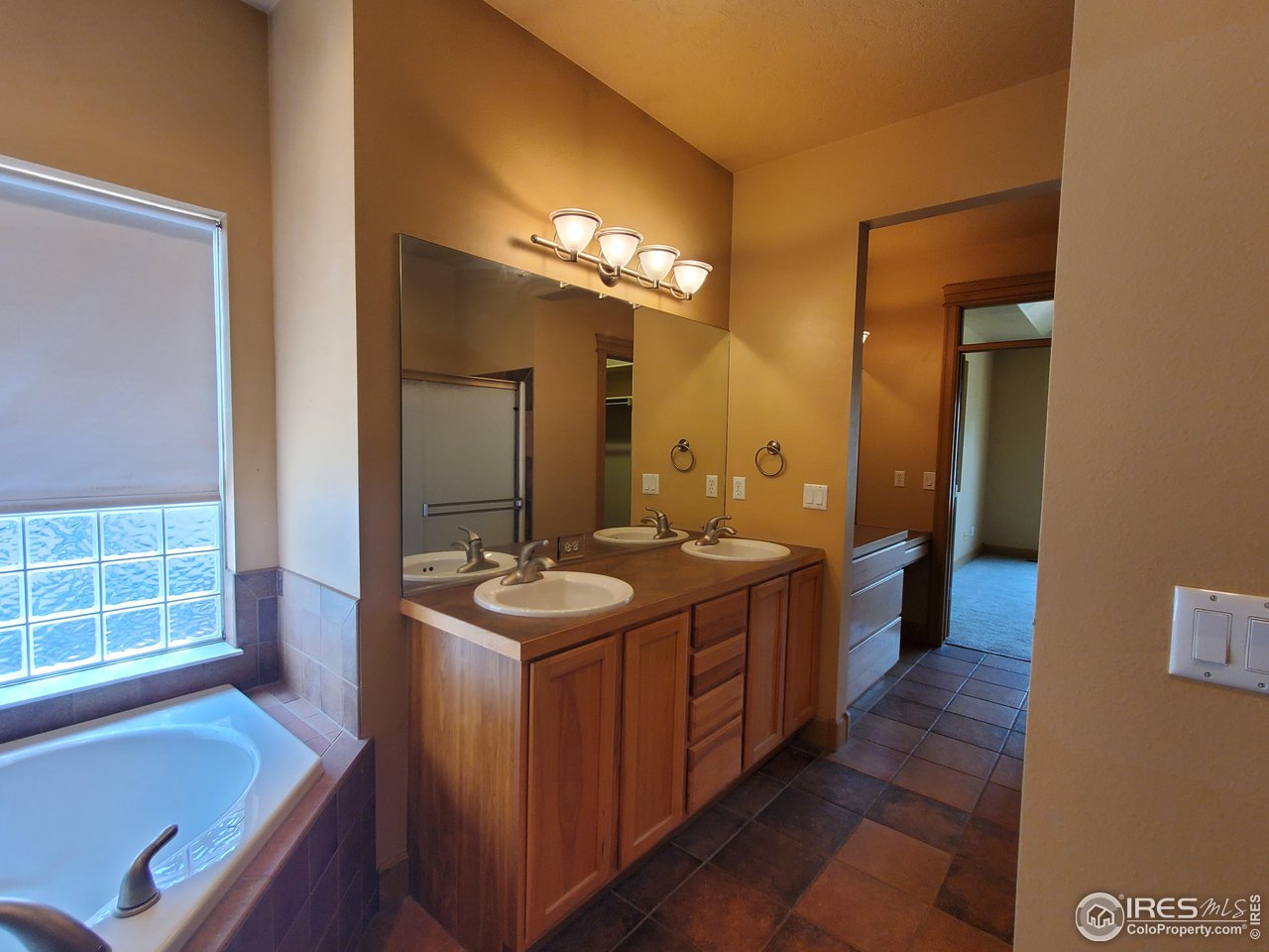 6541 West 18th Street Road Greeley, CO 80634 - Photo 22 of 40 a bathroom with a double vanity sink and a mirror