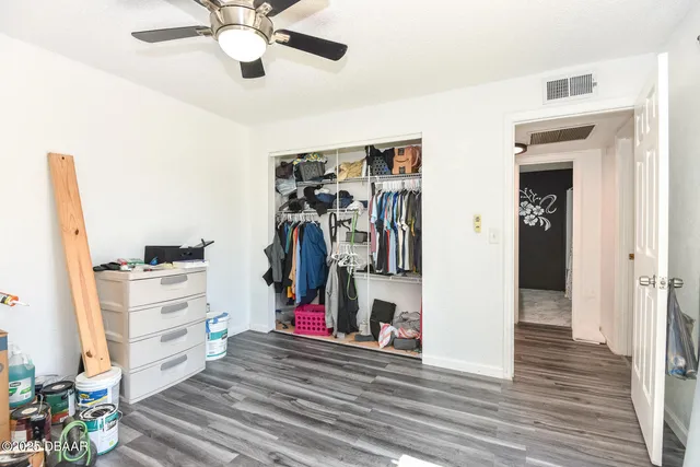 a view of a hallway with closet and a chandelier fan