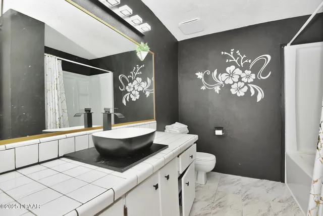 a bath room with a toilet and a large mirror