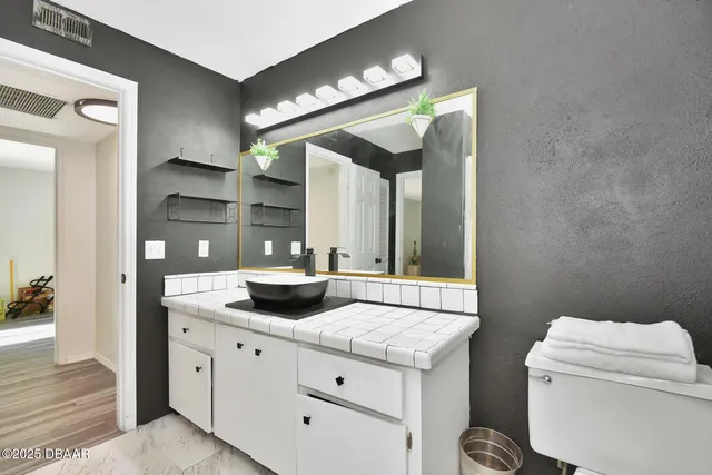 a bathroom with a granite countertop sink and a mirror