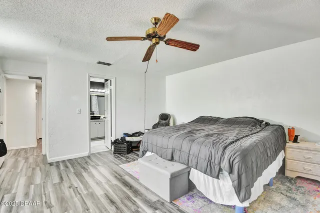 a bedroom with a bed and a ceiling fan