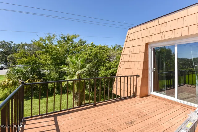 a view of a balcony with wooden floor and fence