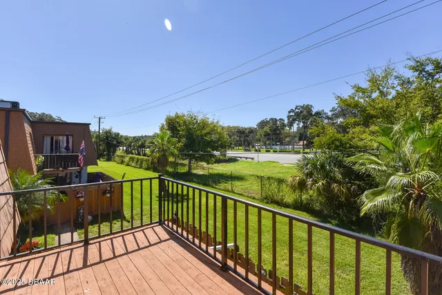 a view of a balcony with floor to ceiling windows with wooden floor