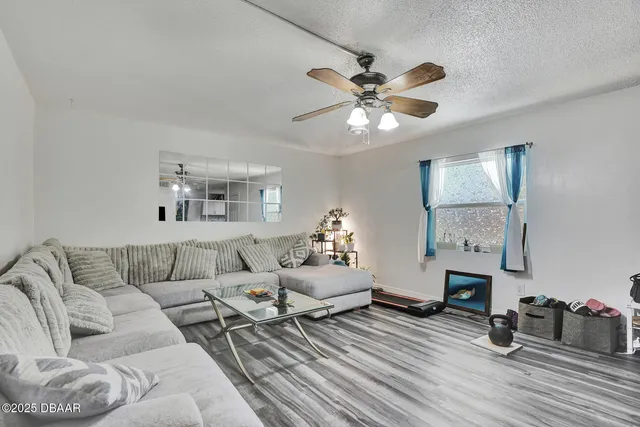 a living room with furniture and a wooden floor