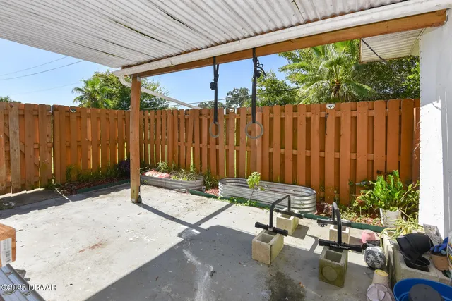 a view of a backyard with a chair and potted plants